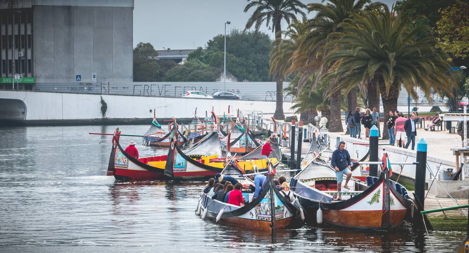 Aveiro, Portugal - May 7, 2018: Tourists walk on famous Moliceiros on a spring evening, traditional boats used to harvest seaweeds in the past