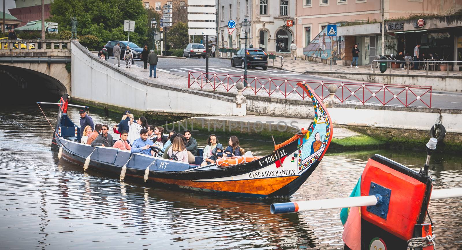 Aveiro, Portugal - May 7, 2018: Tourists walk on famous Moliceiros on a spring evening, traditional boats used to harvest seaweeds in the past