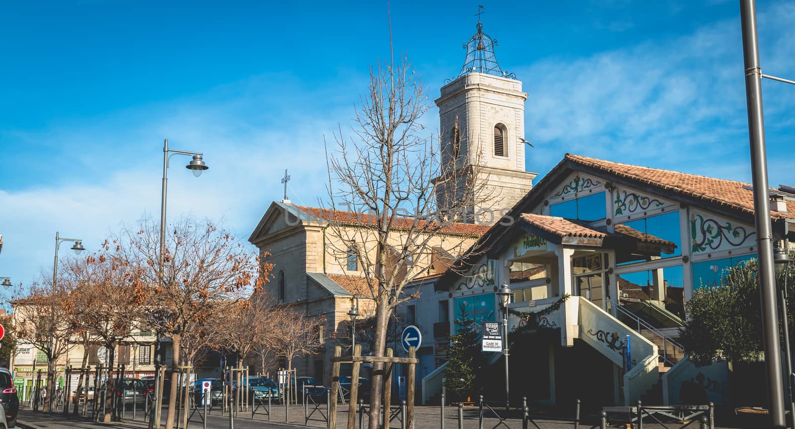 Marseillan, France - December 30, 2018: architectural detail of the Saint Jean-Baptiste church and the La Fabrique media library in the historic city center on a winter day