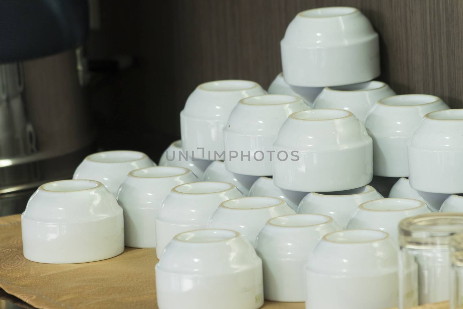 White cups for tea piled on table with plates for coffee-break