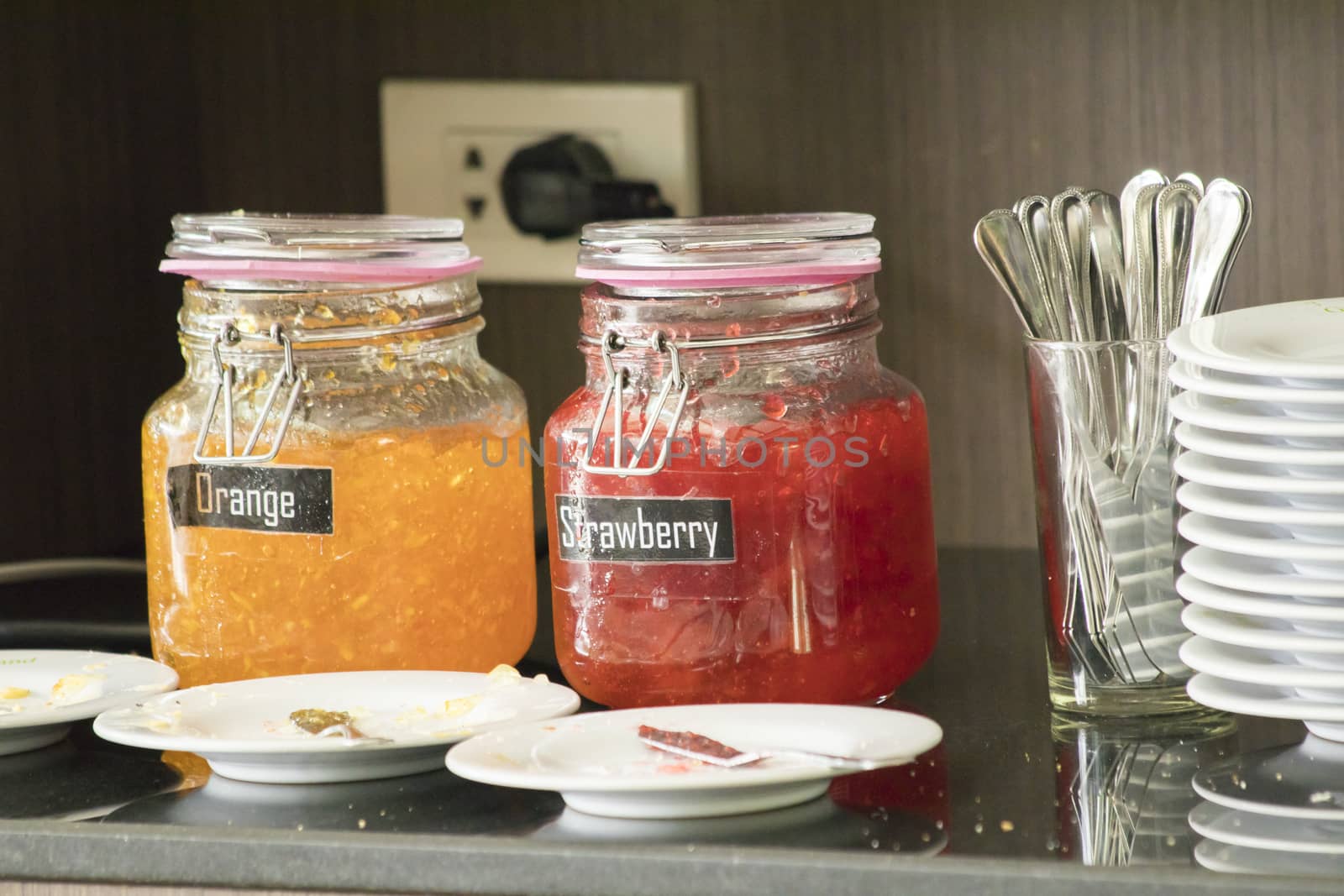 Orange,strawberry jam in glass jars on table in morning breakfast
