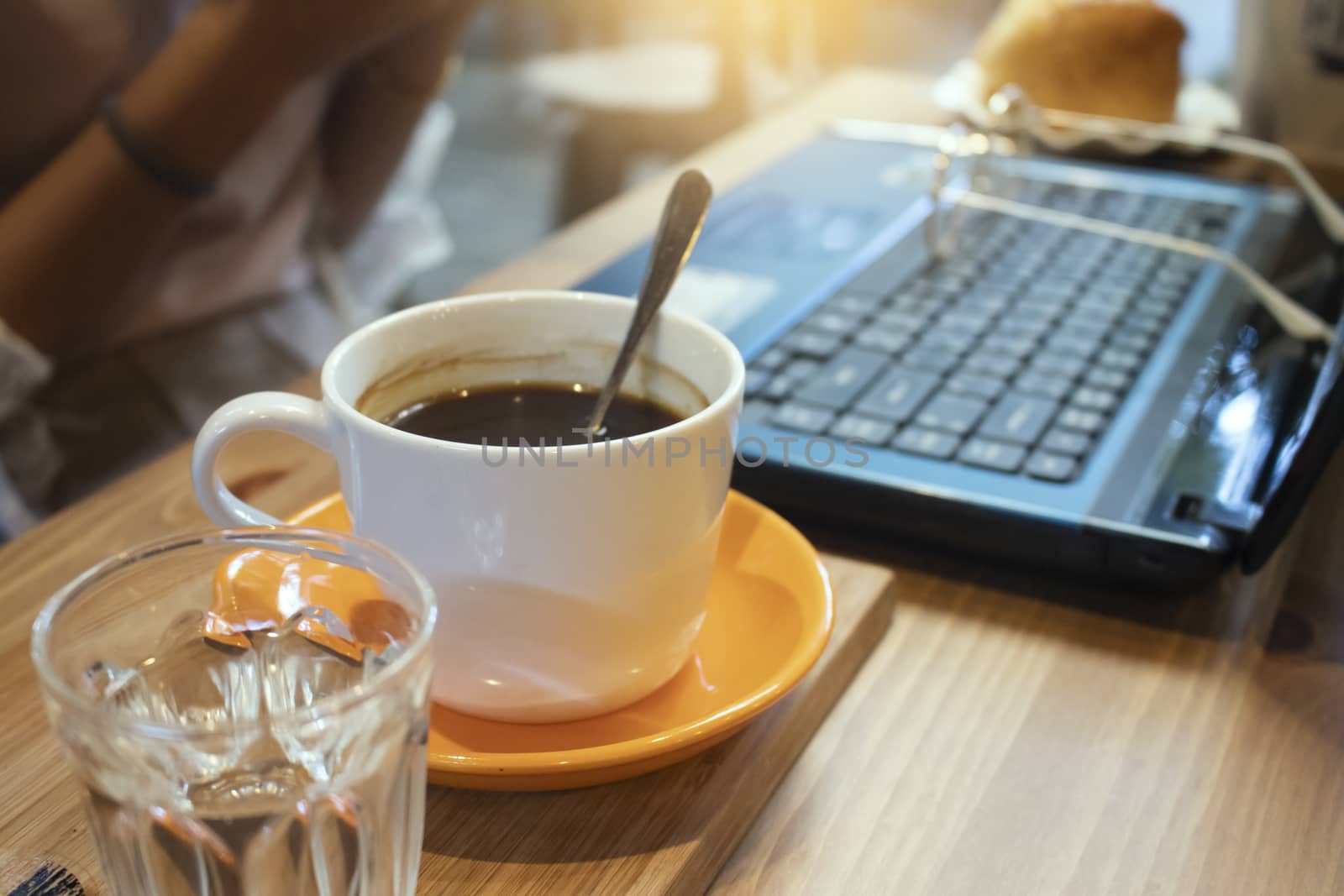 Cup of coffee and laptop on wooden table in coffee shop by Gobba17