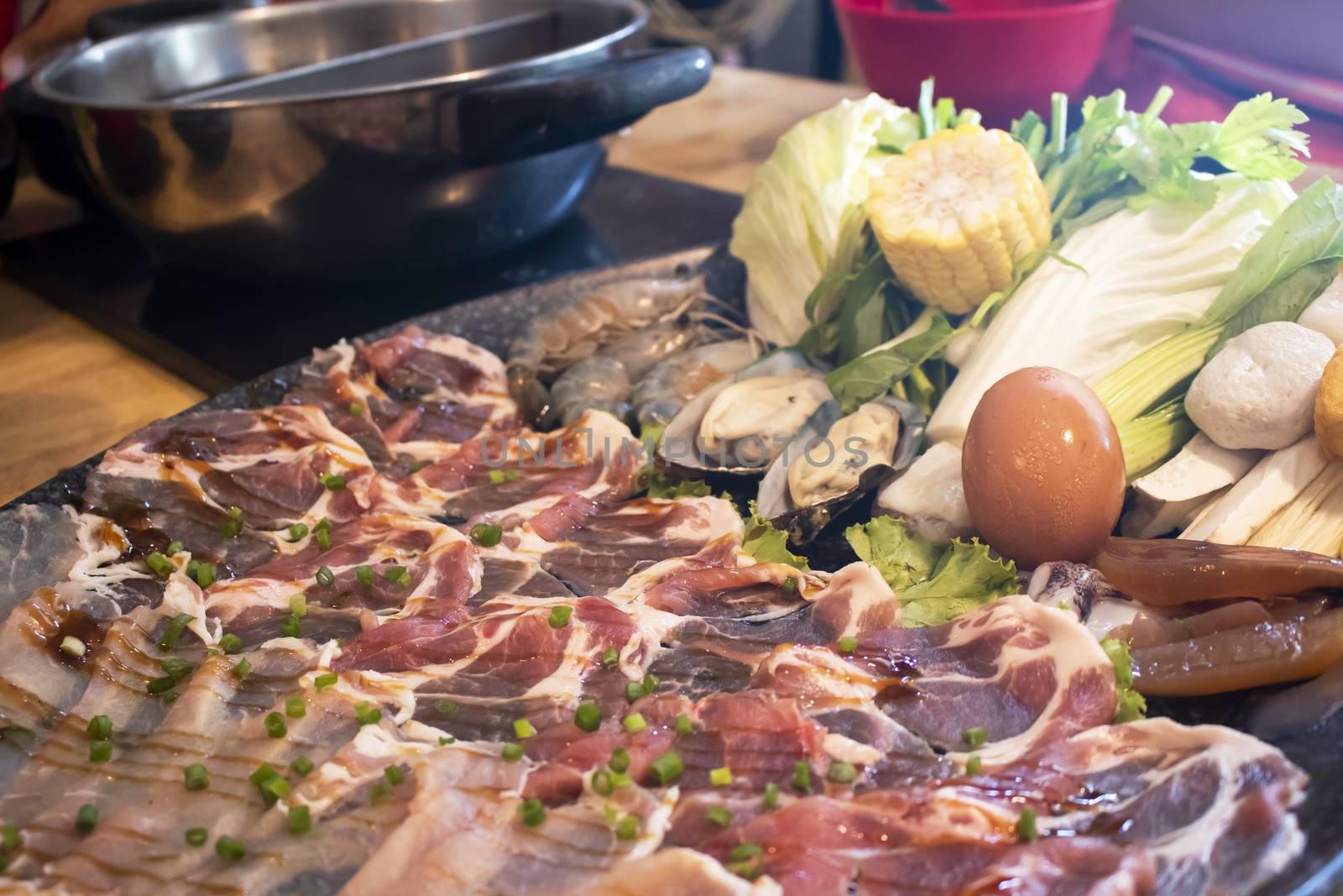 Shabu-shabu platter on table at Japanese restaurant with people eating