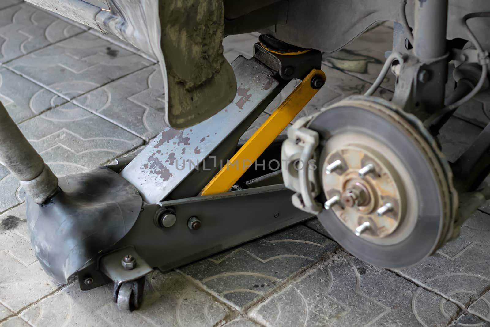 Wheel arch of the car with the removed wheel. Brake disc car wheels with caliper at the service station by jk3030