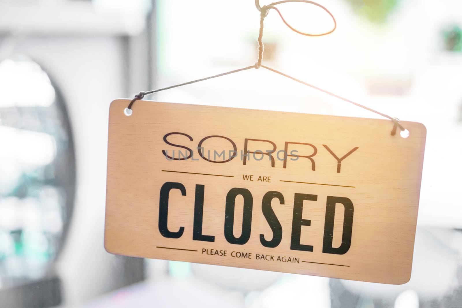 Sorry we are closed sign hang on door of business shop. by Suwant