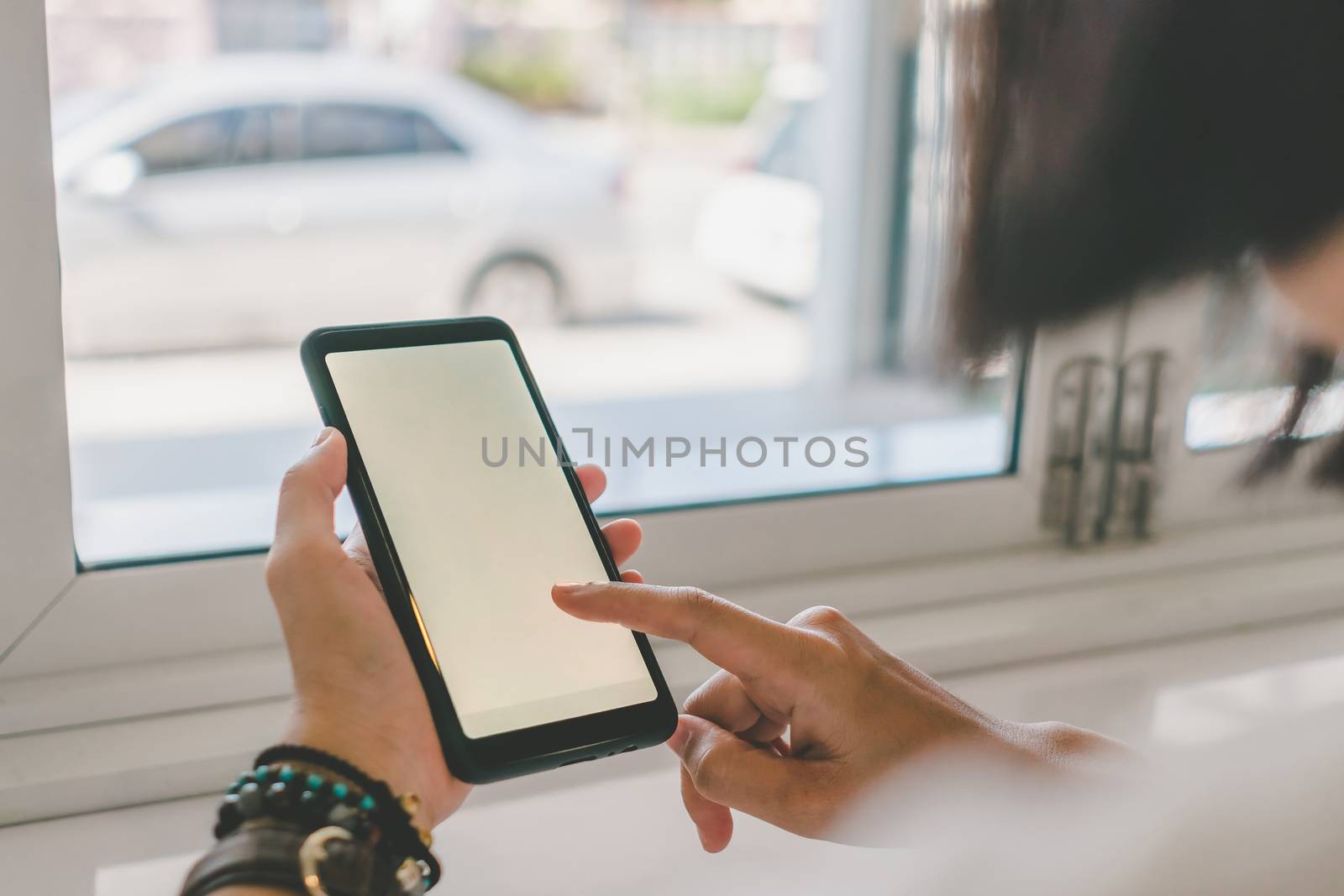 Woman hand use smartphone to do work business, social network, communication in public cafe work space area.