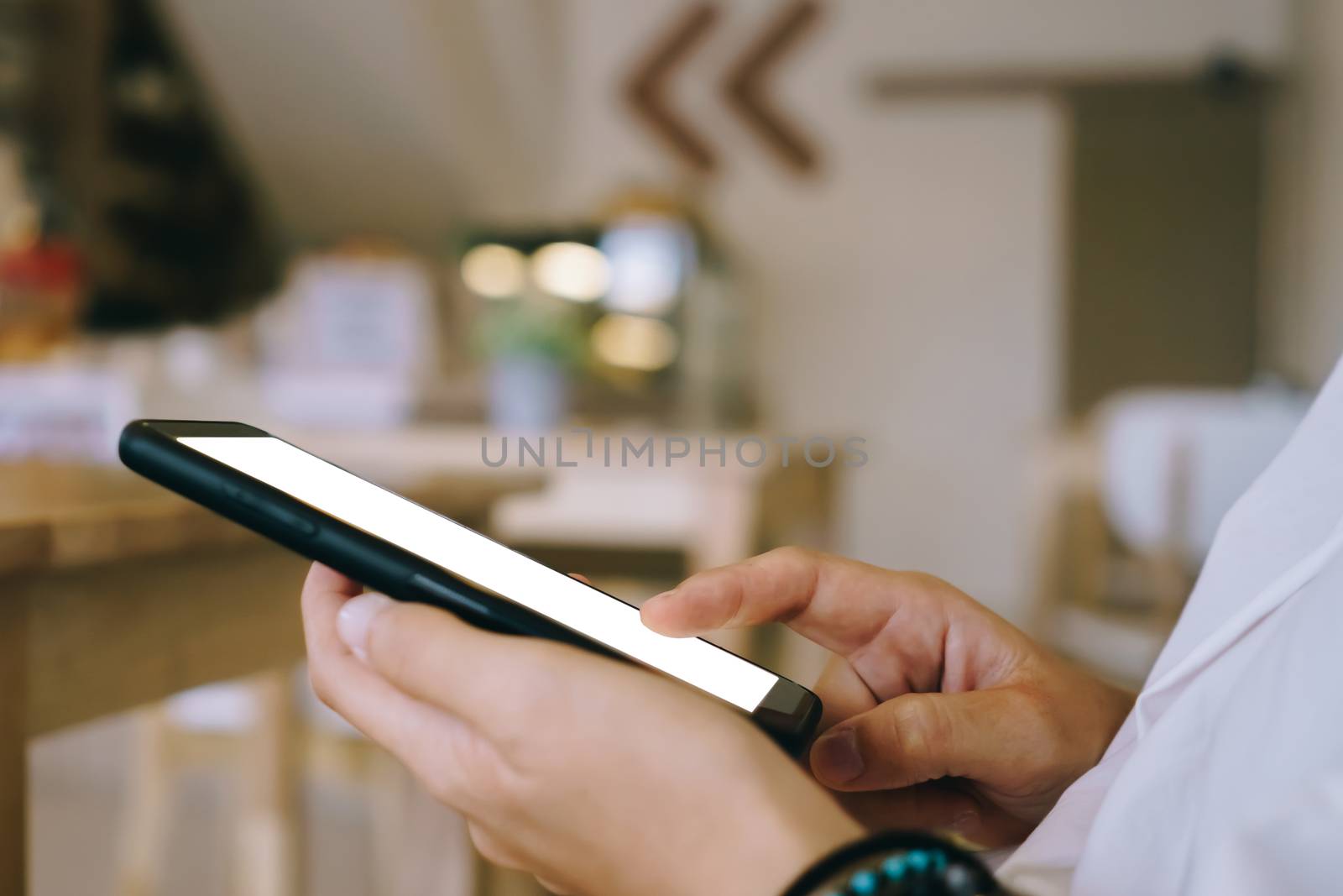 Woman hand use smartphone to do work business, social network, communication in public cafe work space area.