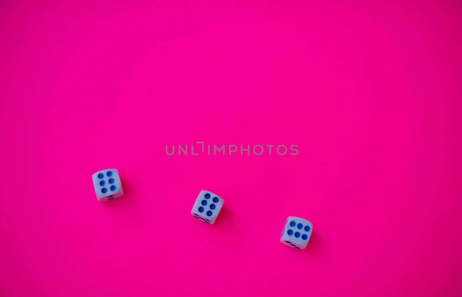Three dice with number six isolated against pink background
