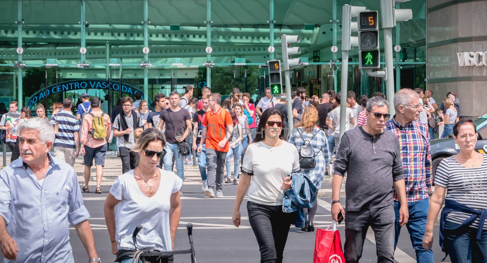 Lisbon, Portugal - May 7, 2018: People crossing a street on a zebra crossing in front of the Vasco da Gama shopping center on a spring day