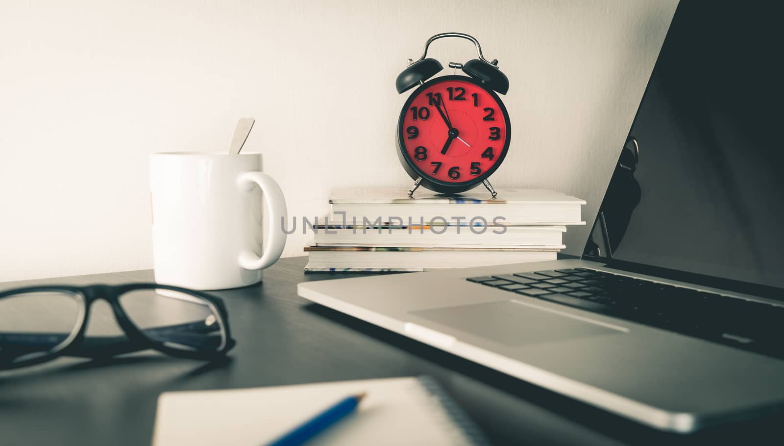 Red Alarm Clock on office table with objects