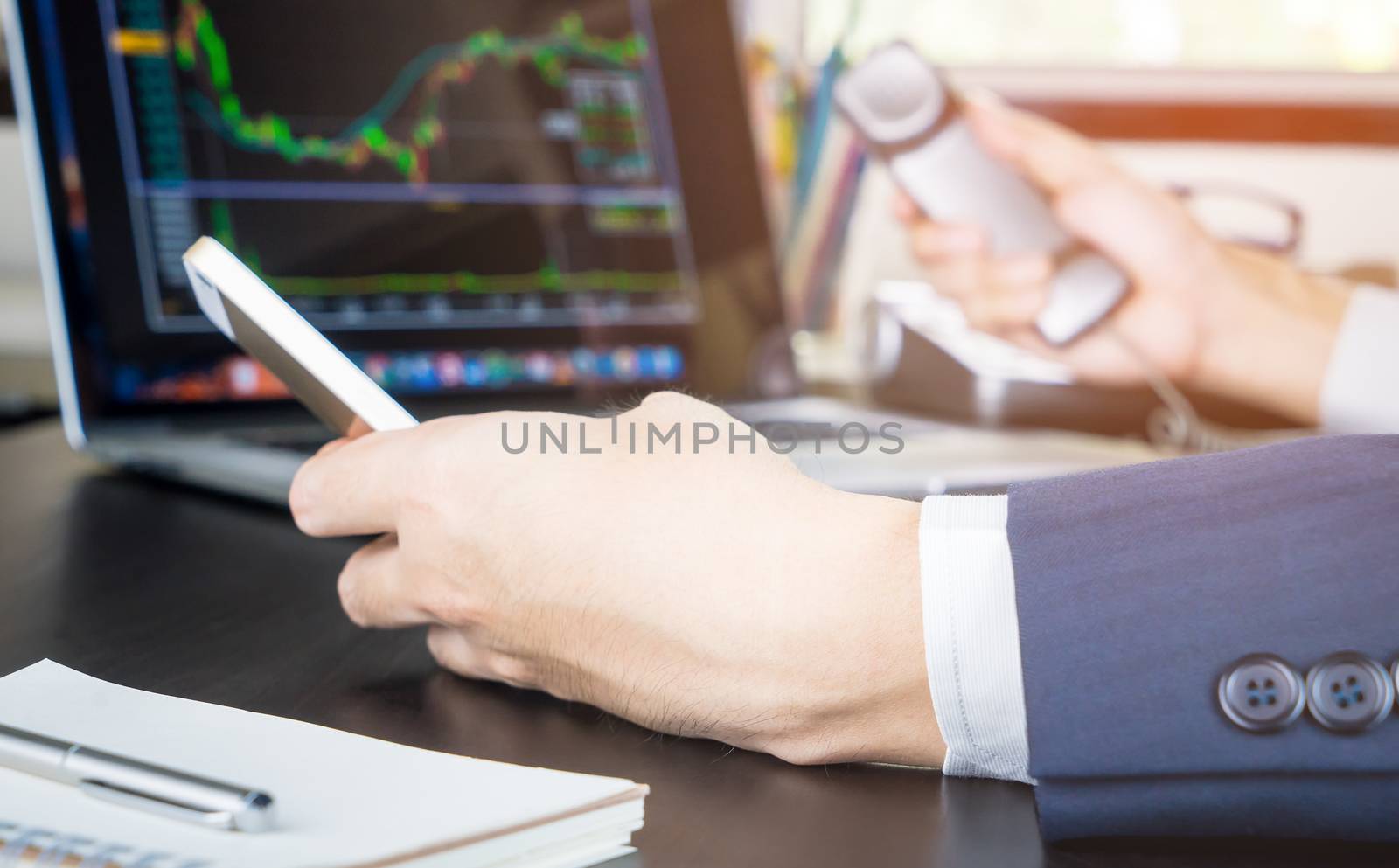 Stock Broker with both hand on the phone making call to traders by junce