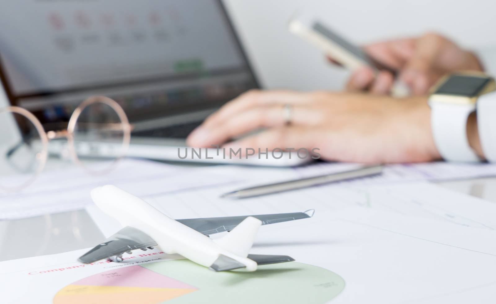 Business man is planning his business travel on computer and smartphone