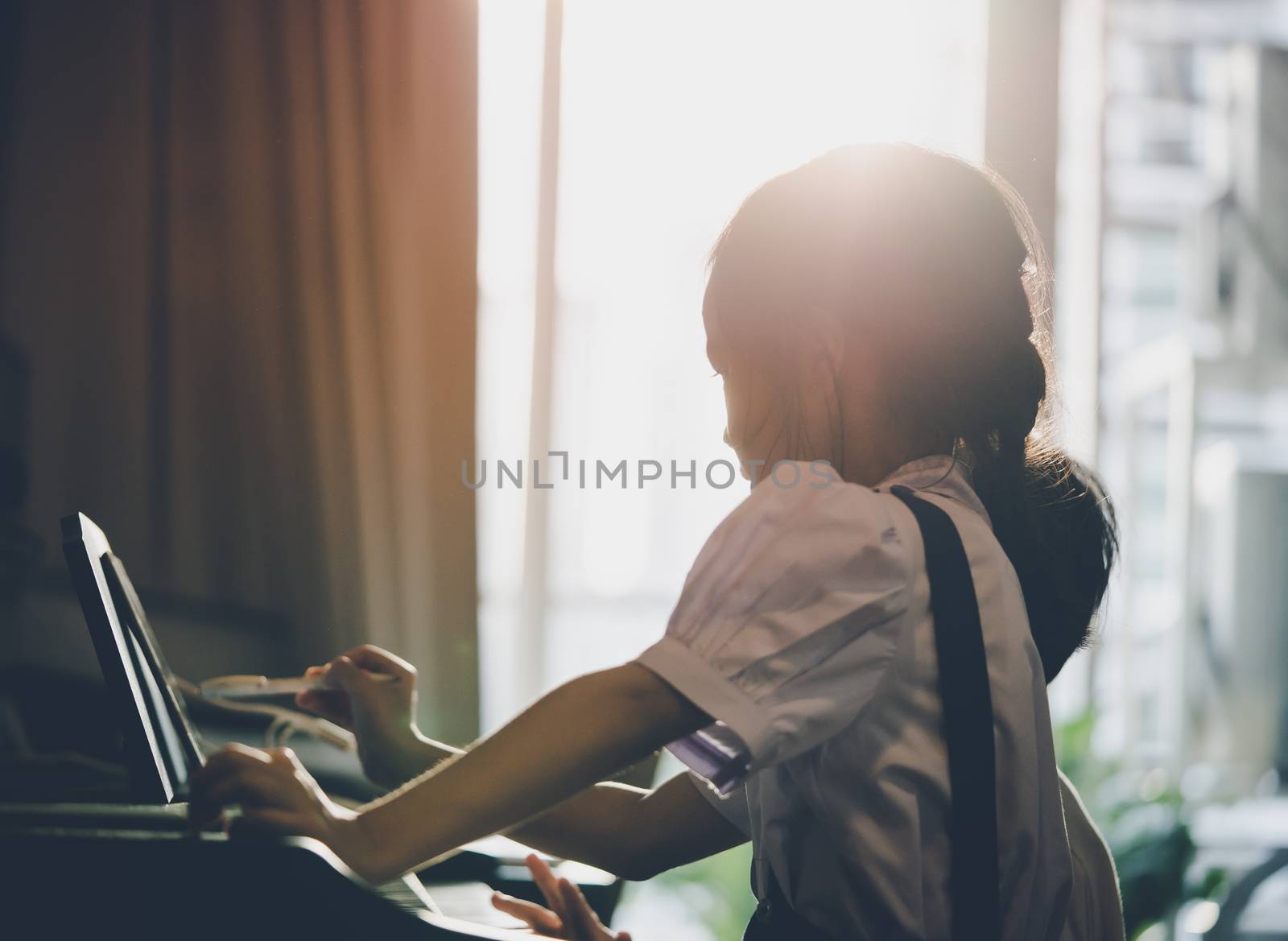 Little girl is playing with piano and Music Tablet at home by junce