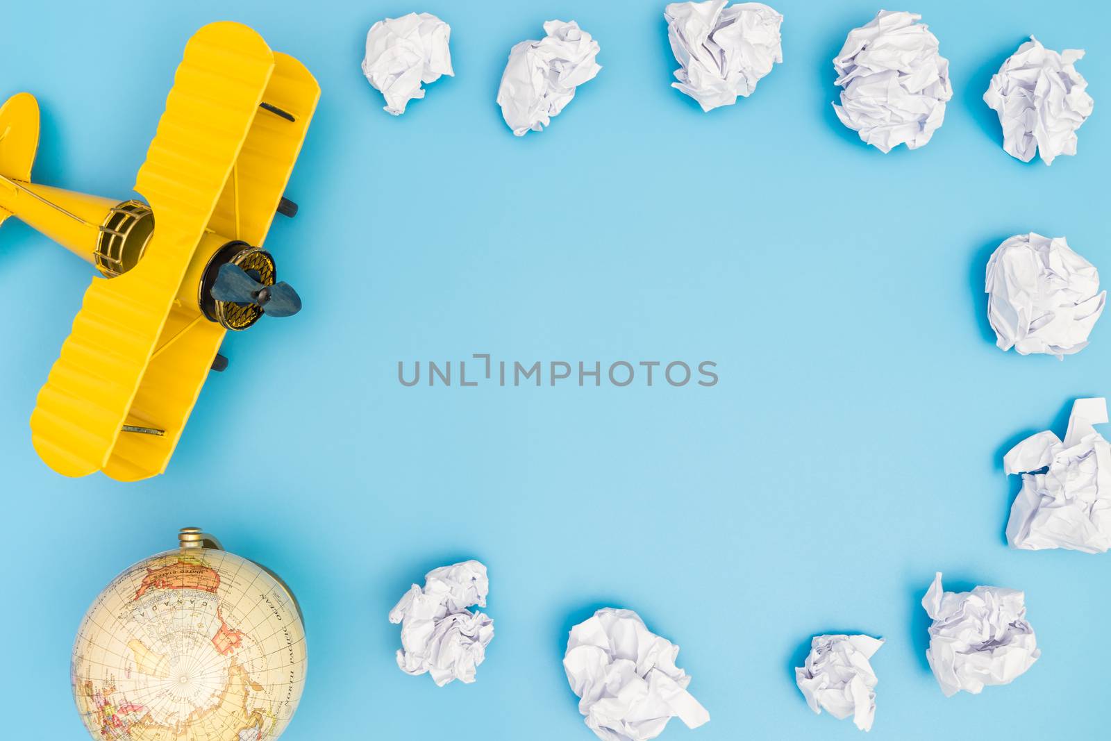 Yellow toy plane on paper cloud on blue framed copy space by junce