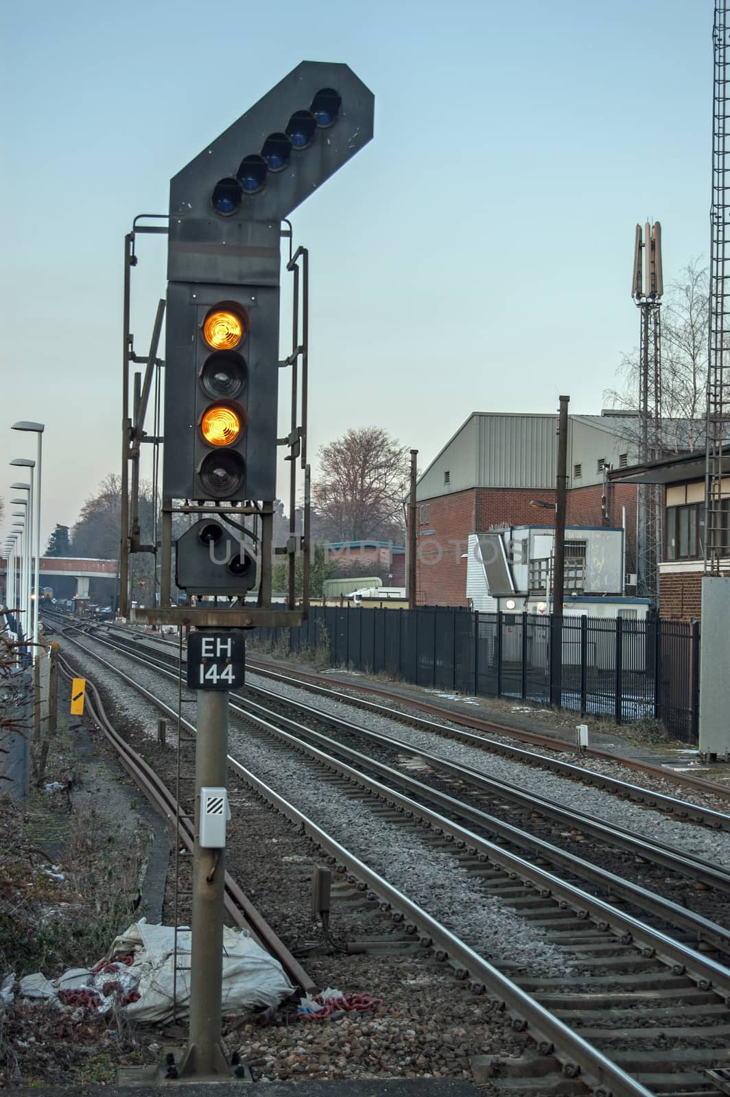 Double yellow railway signal on train track in UK by BasPhoto