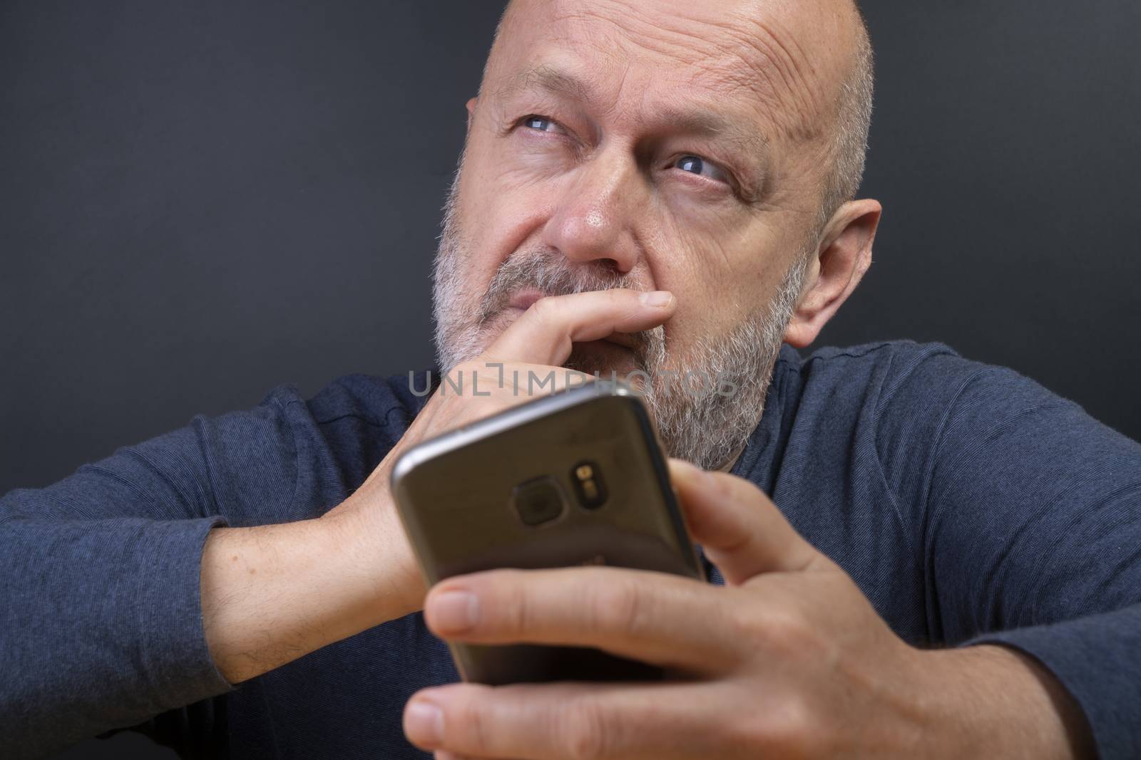 a man while reflecting before retweeting a message on his mobile phone