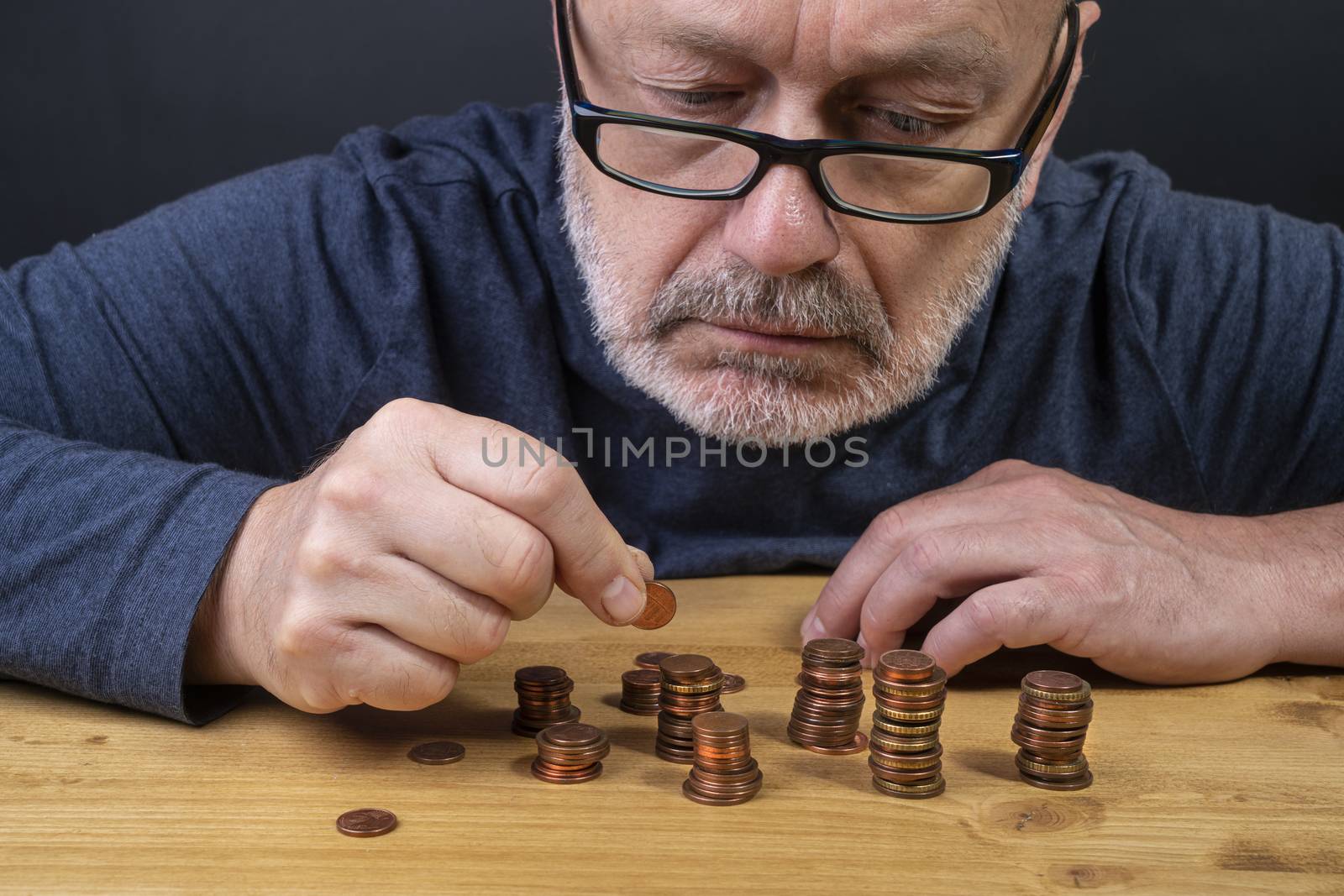 a man counting in coins on a table in a time of crisis