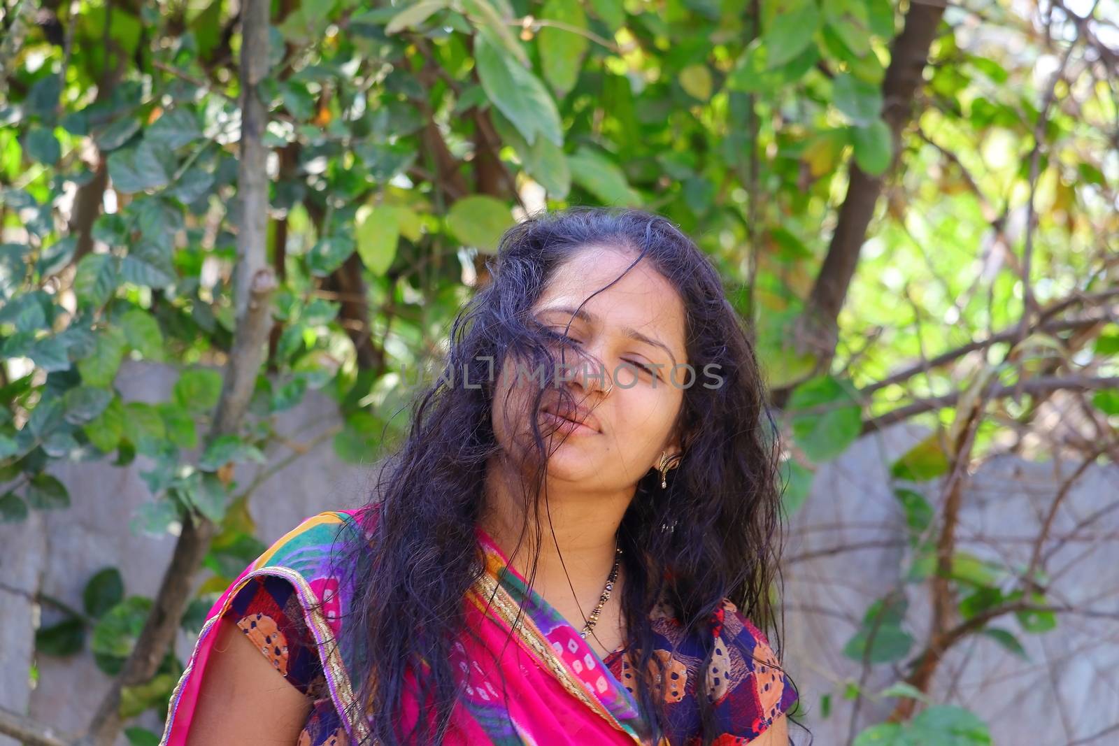 front view of a young Indian girl standing in the home garden
