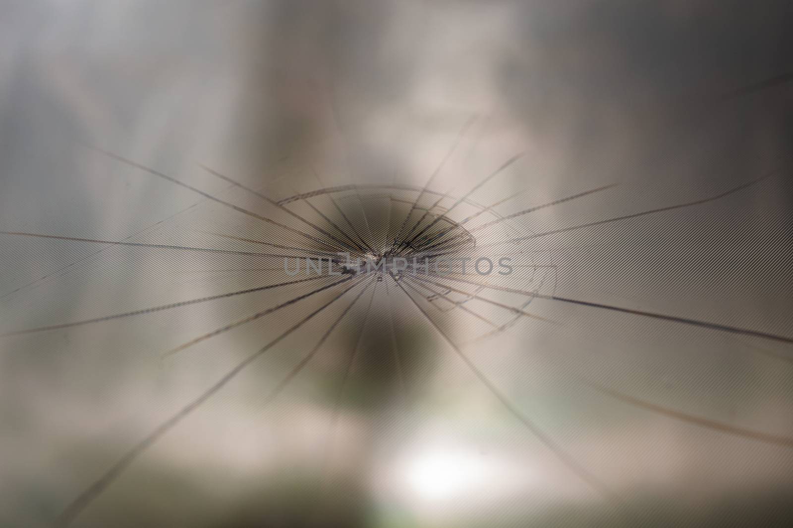 abstract background of broken tft lcd with localized radial cracks from one hit - close-up with selective focus and background blur