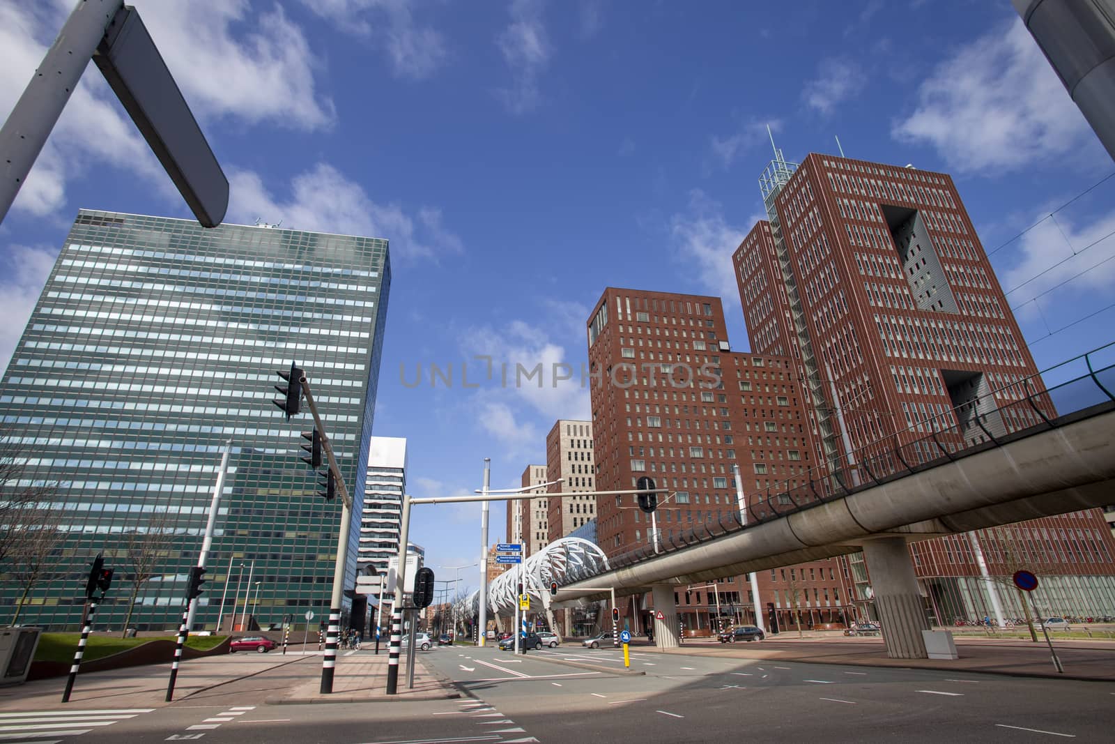 Up view of The Hague business center with the aerial tram rail bordered by tall corporate building under a pur cloudy sky, Netherlands