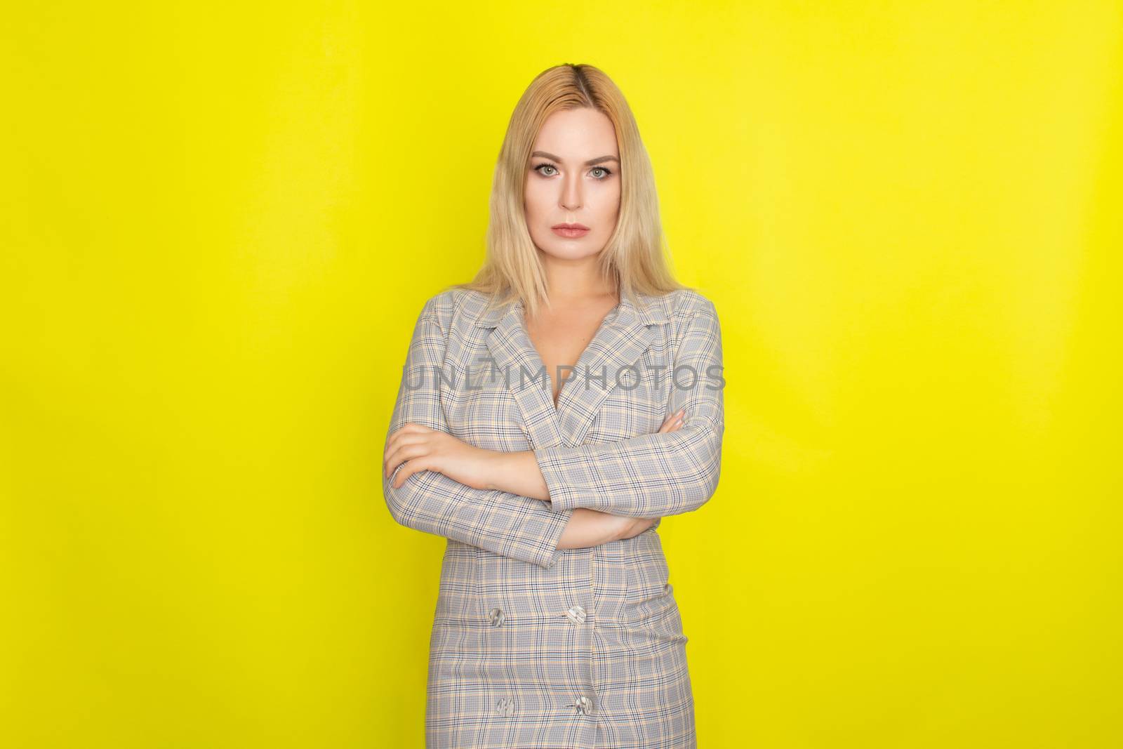 Attractive blonde woman in plaid jacket dress