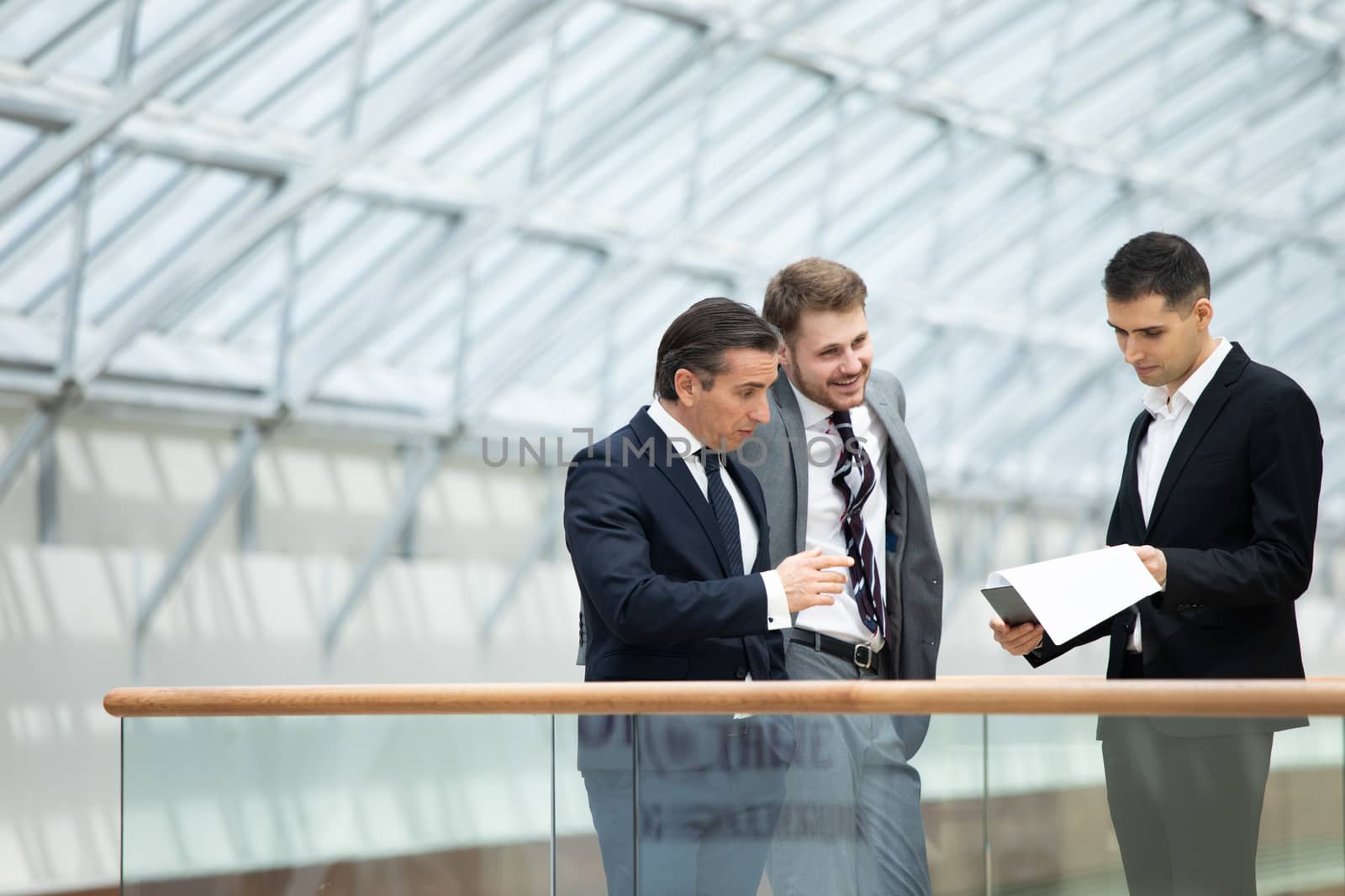 Business people having informal meeting in modern office discussing documents