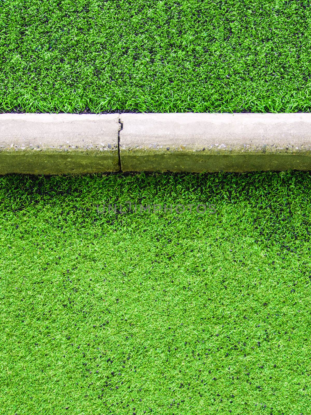 Texture of plastic artificial grass and concrete border of schoo by Satakorn