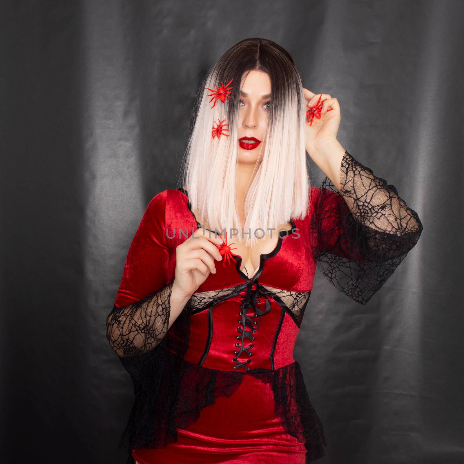 Blonde woman in vampire costume with many red spiders on her hair by Bonda