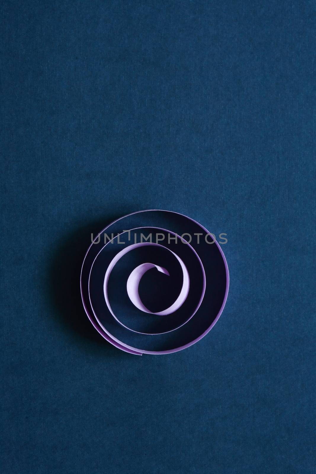 Purple spiral made from paper on dark blue background