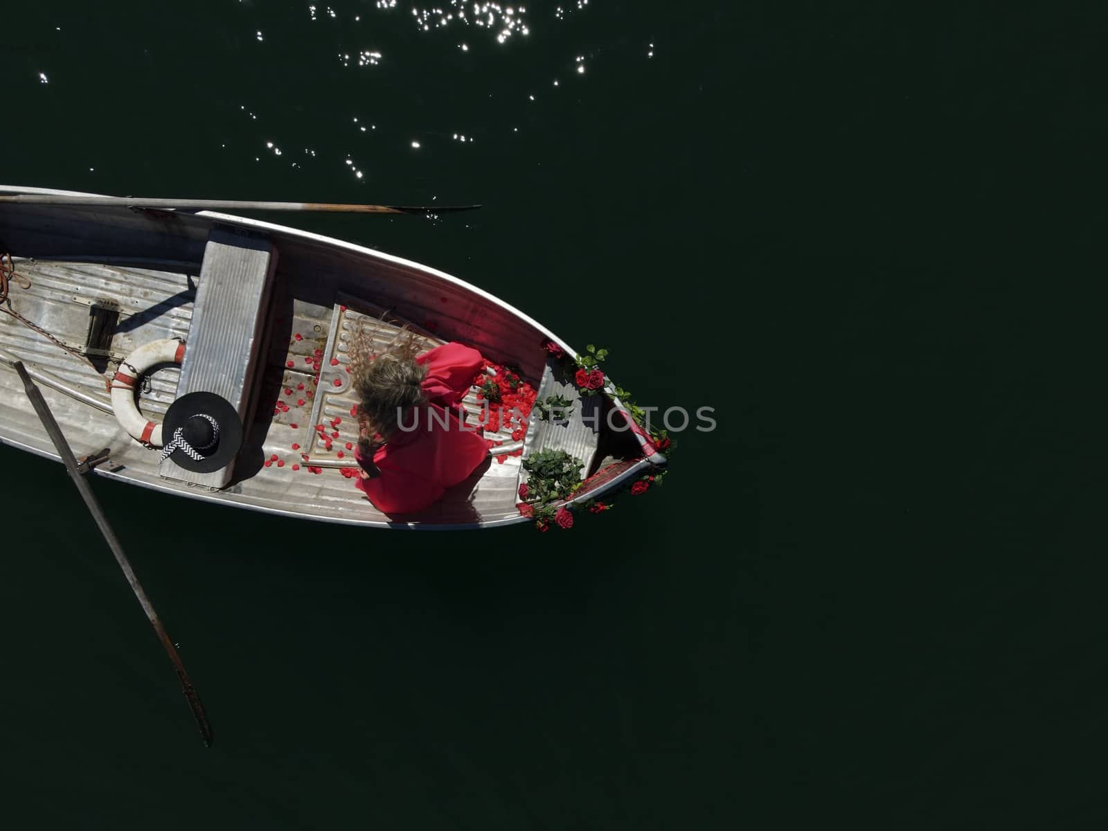 Romantic woman with long blond hair on boat with roses and flowe by PeterHofstetter