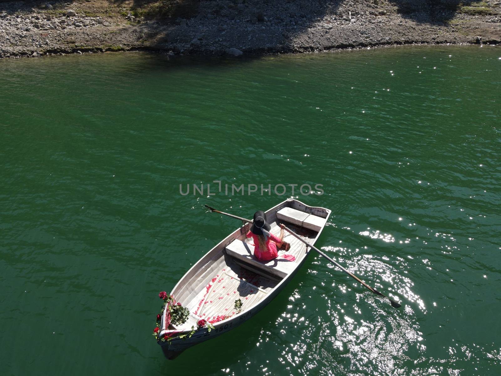 woman with long blond hair on boat on a blue lake by PeterHofstetter