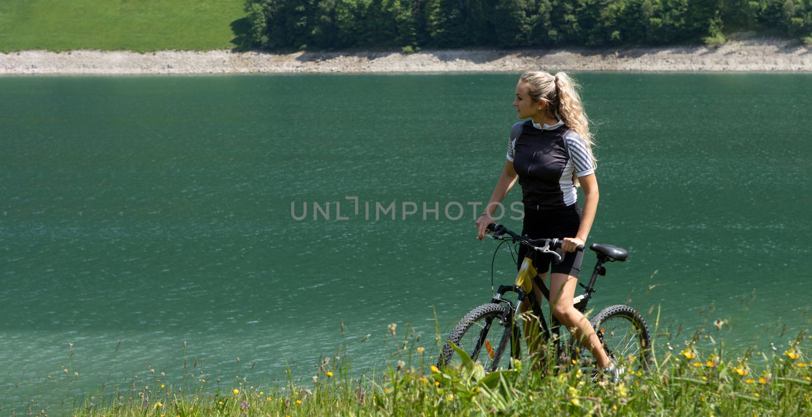 Life style woman with long blond hair on mountain bike in Swiss Alps