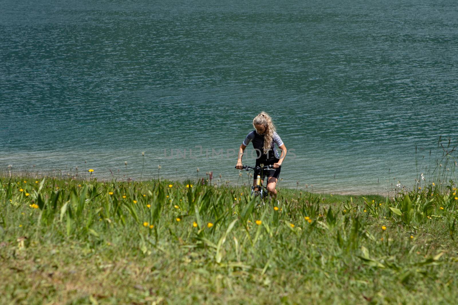 Life style woman with long blond hair on mountain bike in Swiss by PeterHofstetter