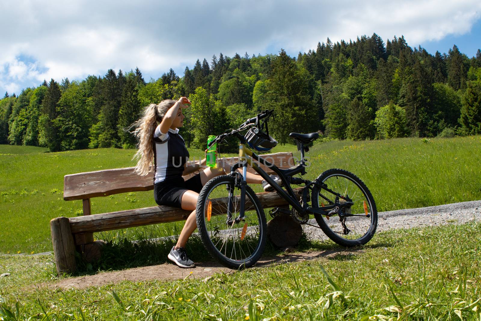 Life style woman with long blond hair on mountain bike in Swiss Alps