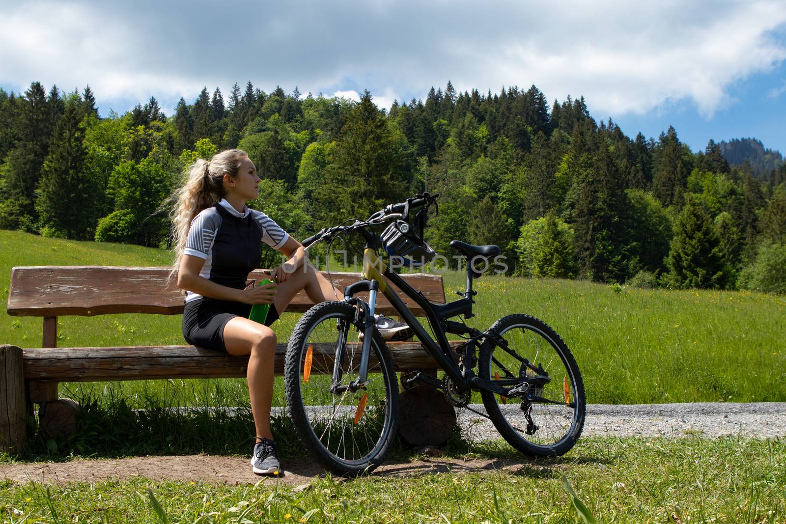 Life style woman with long blond hair on mountain bike in Swiss Alps