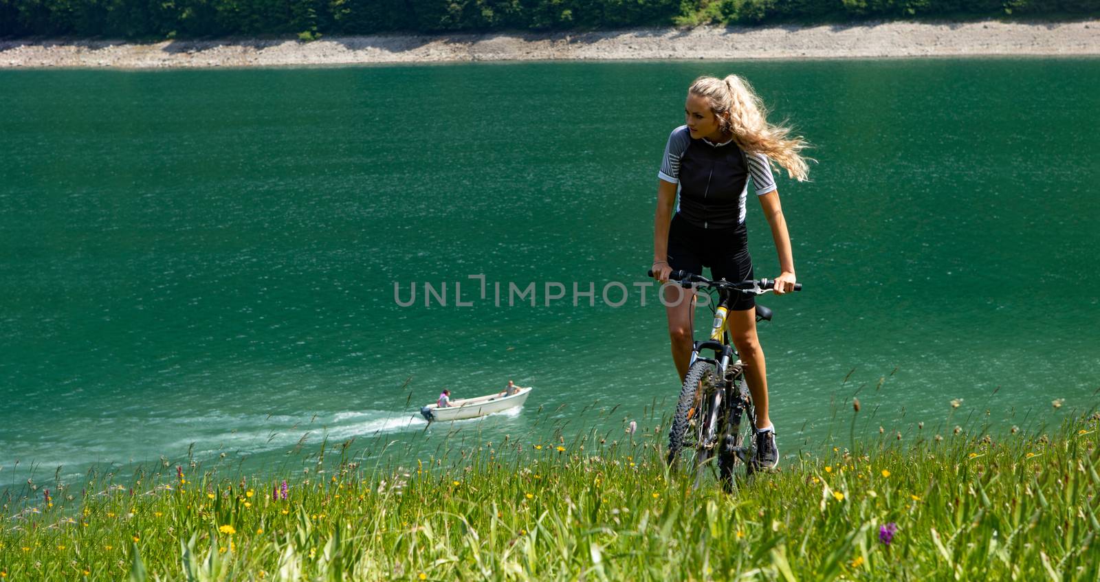 Life style woman with long blond hair on mountain bike in Swiss Alps