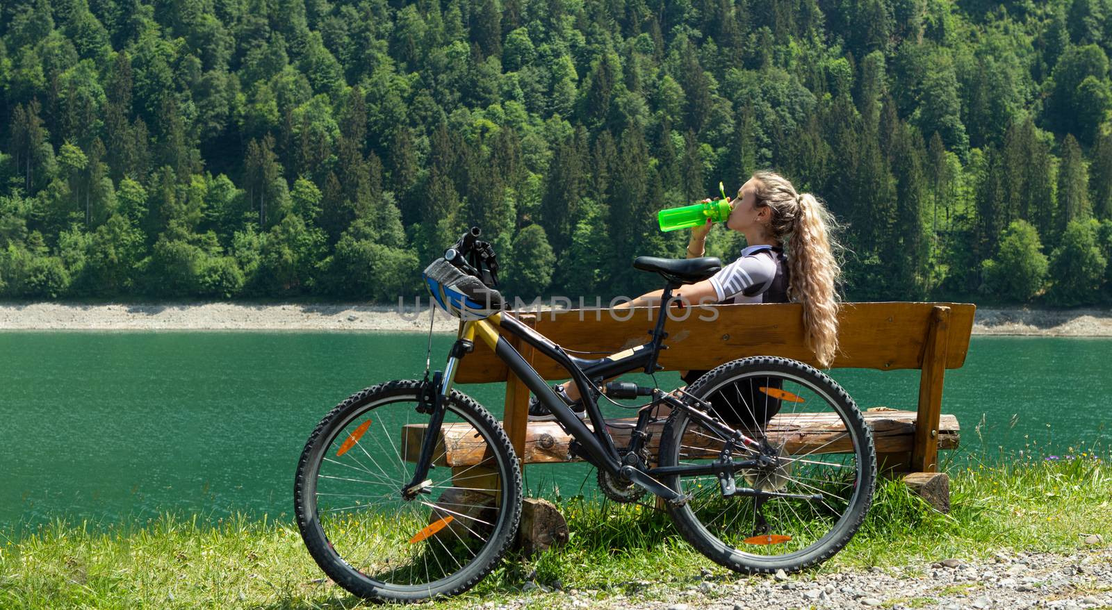 Life style woman with long blond hair on mountain bike in Swiss Alps