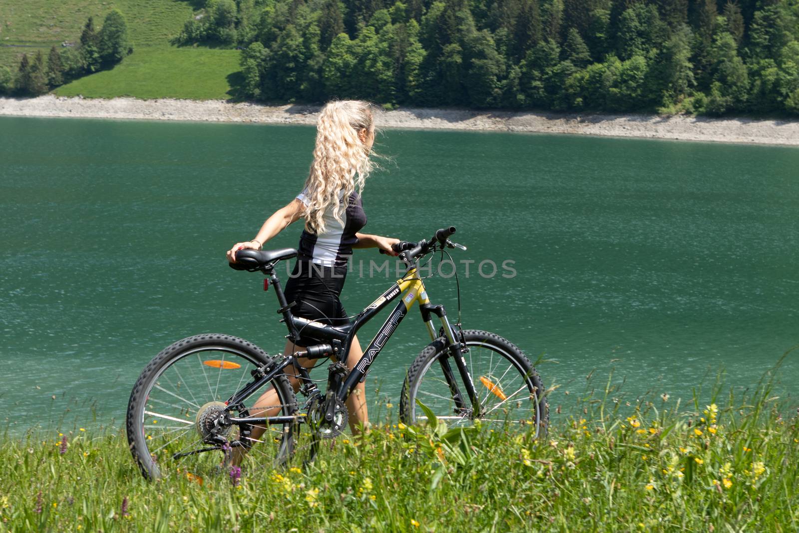 Life style woman with long blond hair on mountain bike in Swiss Alps