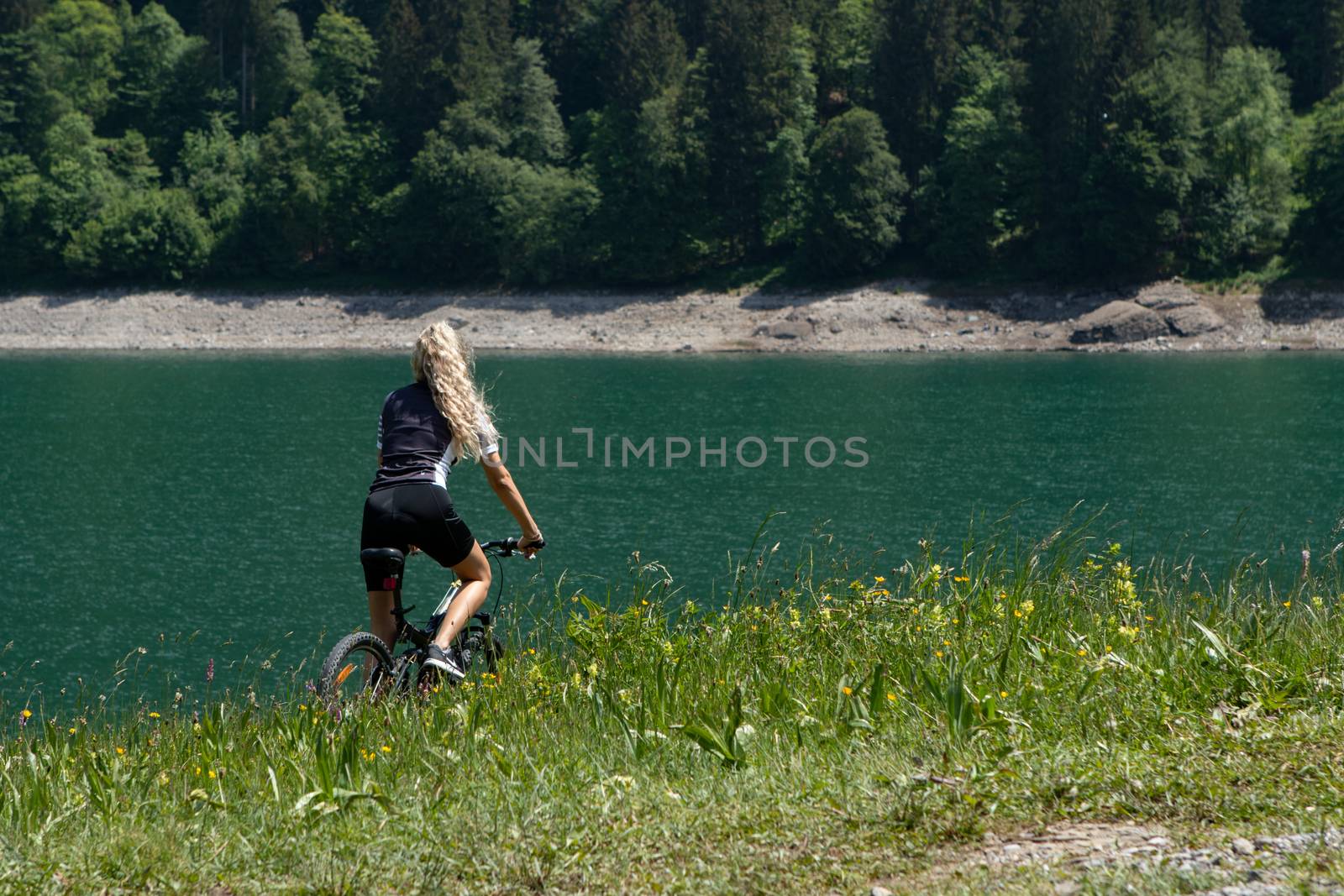 Life style woman with long blond hair on mountain bike in Swiss