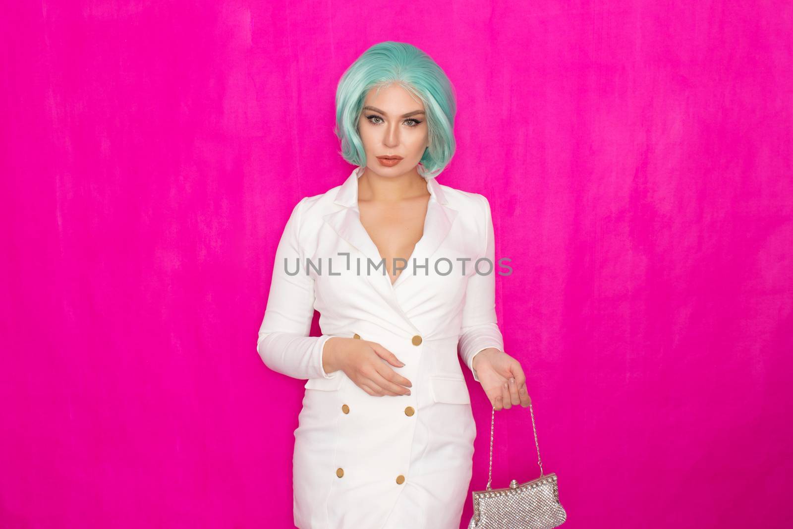 Beautiful young woman with menthol short hair in a white business jacket dress holding a silver small handbag