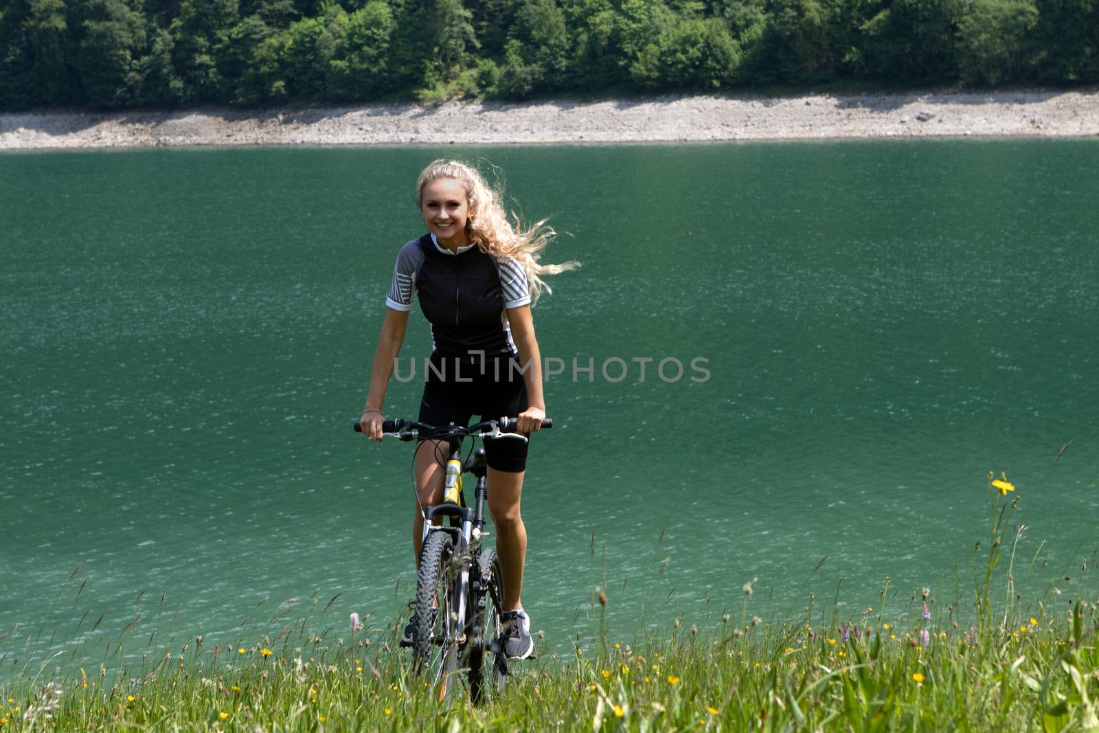 Life style woman with long blond hair on mountain bike in Swiss Alps