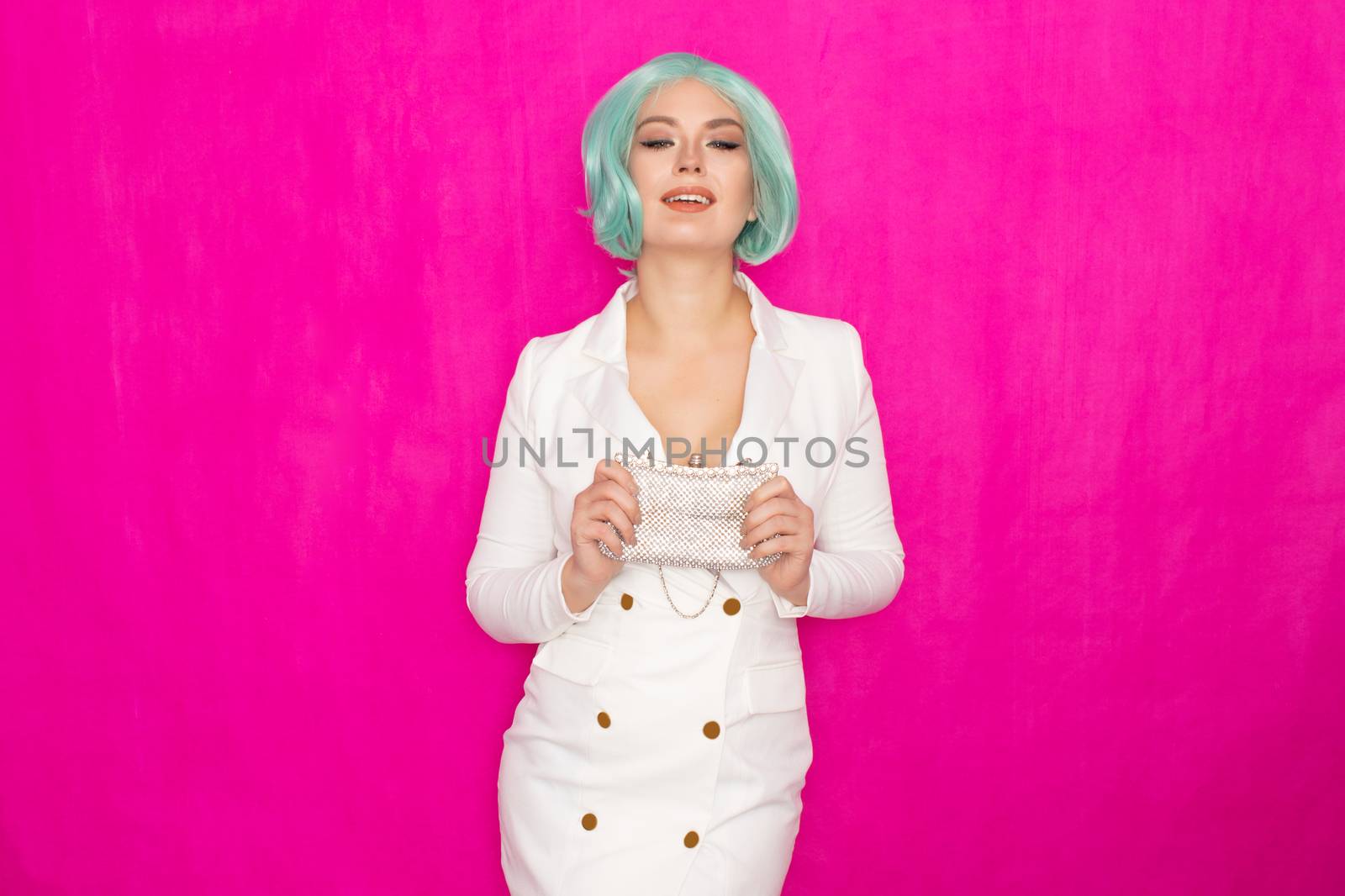 Beautiful young woman with menthol short hair in a white business jacket dress holding a silver small handbag