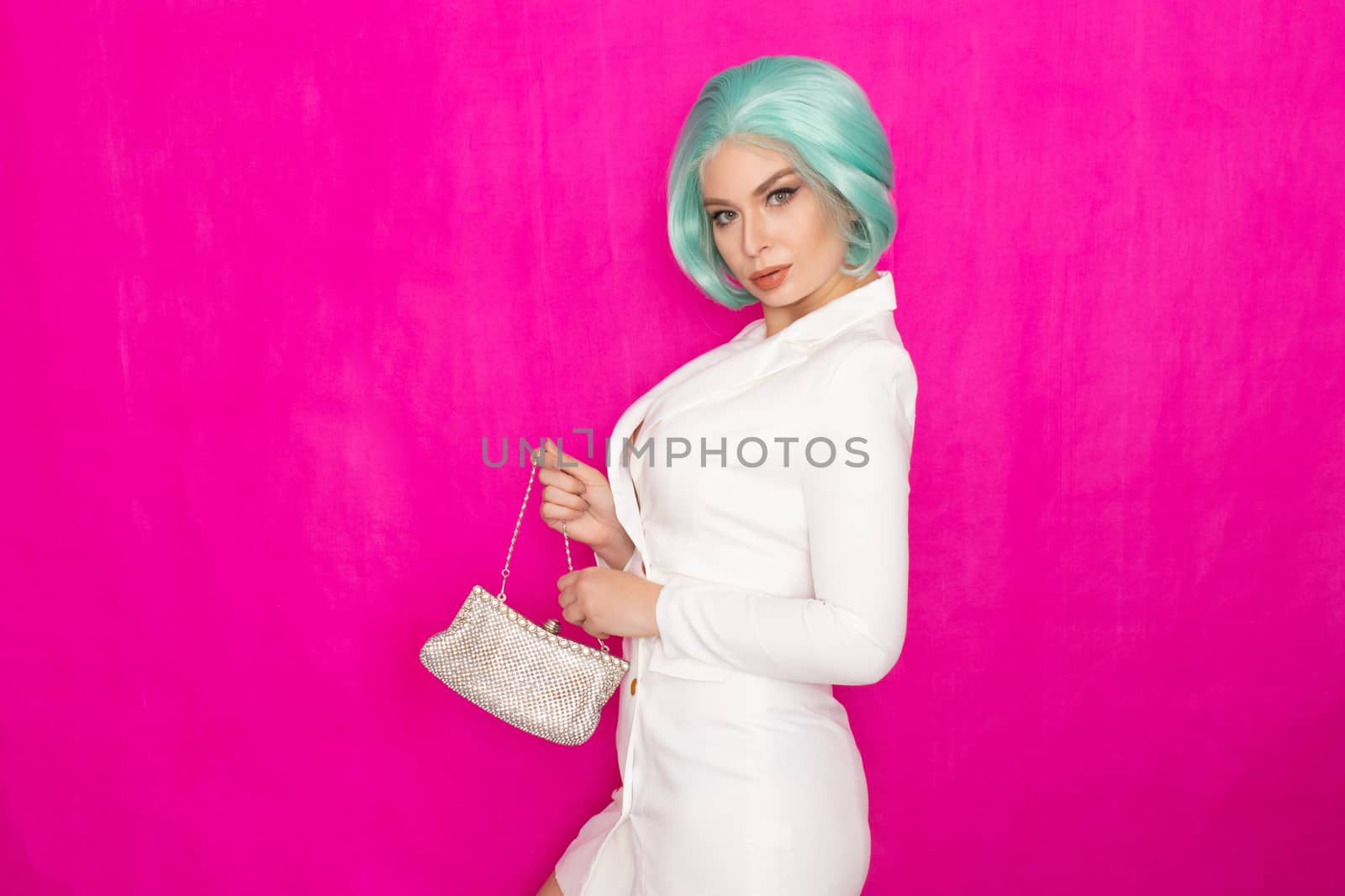 Beautiful young woman with menthol short hair in a white business jacket dress holding a silver small handbag