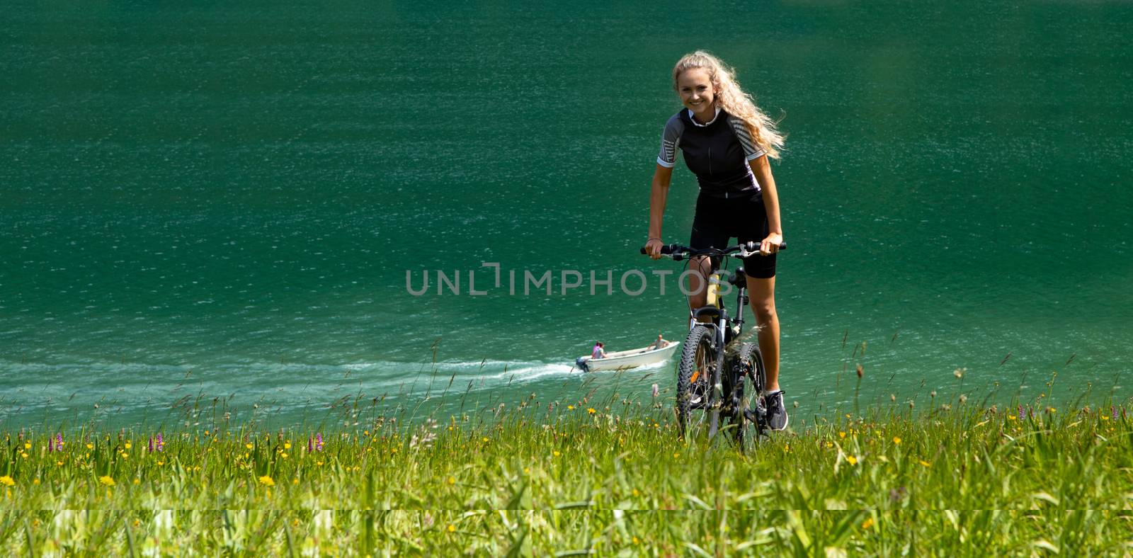 Life style woman with long blond hair on mountain bike in Swiss by PeterHofstetter