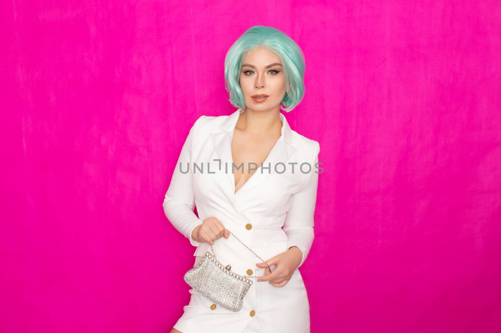 Beautiful young woman with menthol short hair in a white business jacket dress holding a silver small handbag