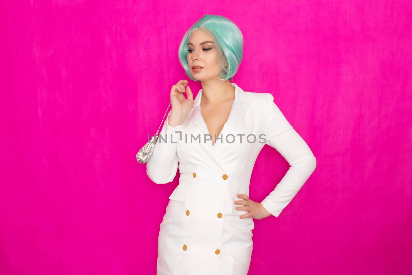 Beautiful young woman with menthol short hair in a white business jacket dress holding a silver small handbag