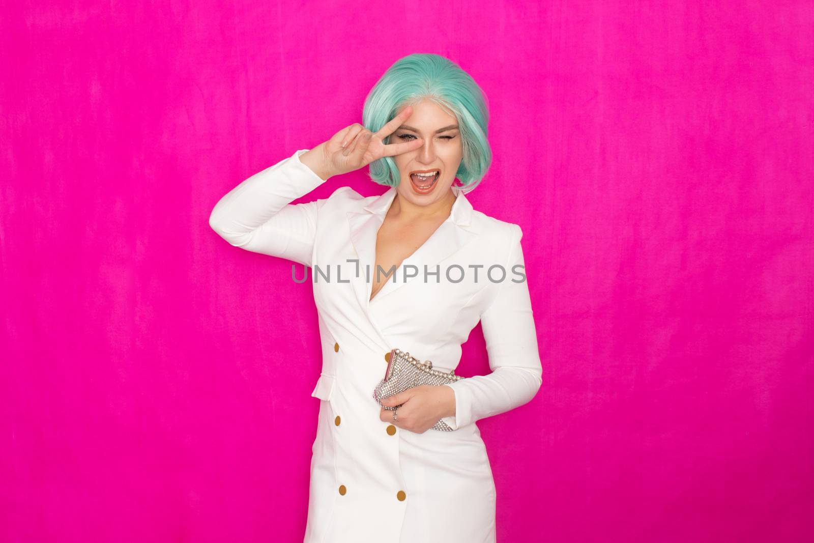 Beautiful young woman with menthol short hair in a white business jacket dress holding a silver small handbag