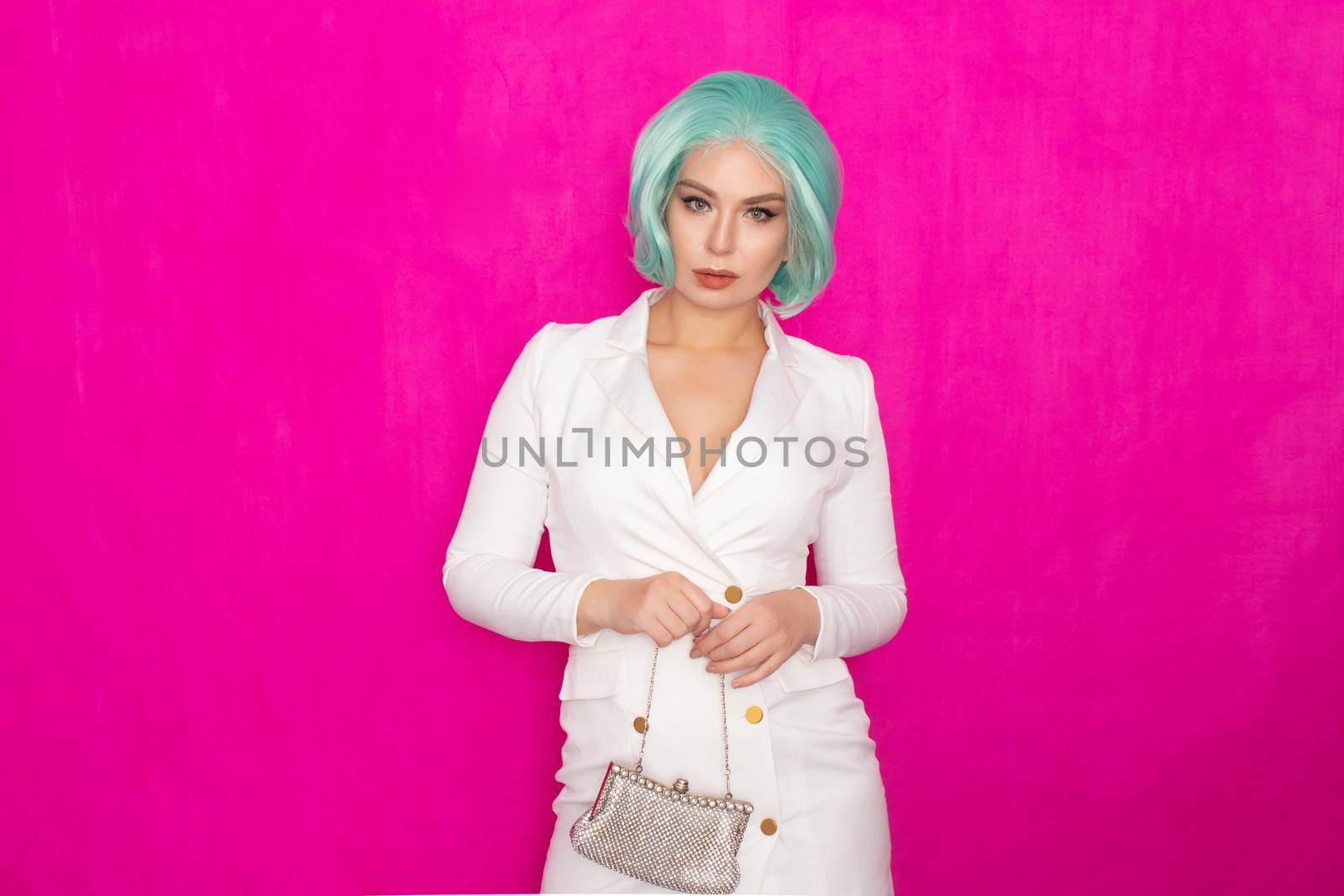 Beautiful young woman with menthol short hair in a white business jacket dress holding a silver small handbag