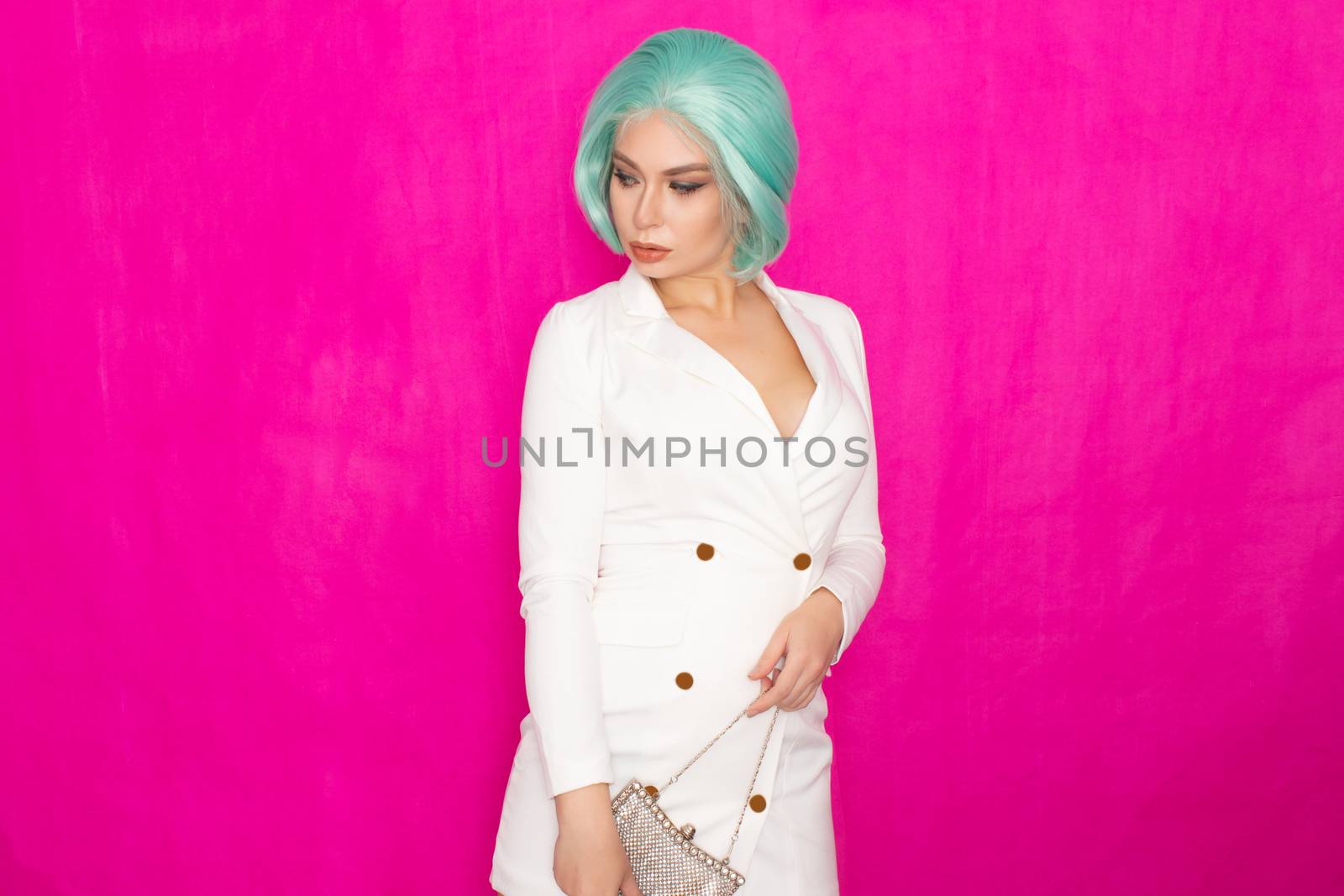 Beautiful young woman with menthol short hair in a white business jacket dress holding a silver small handbag