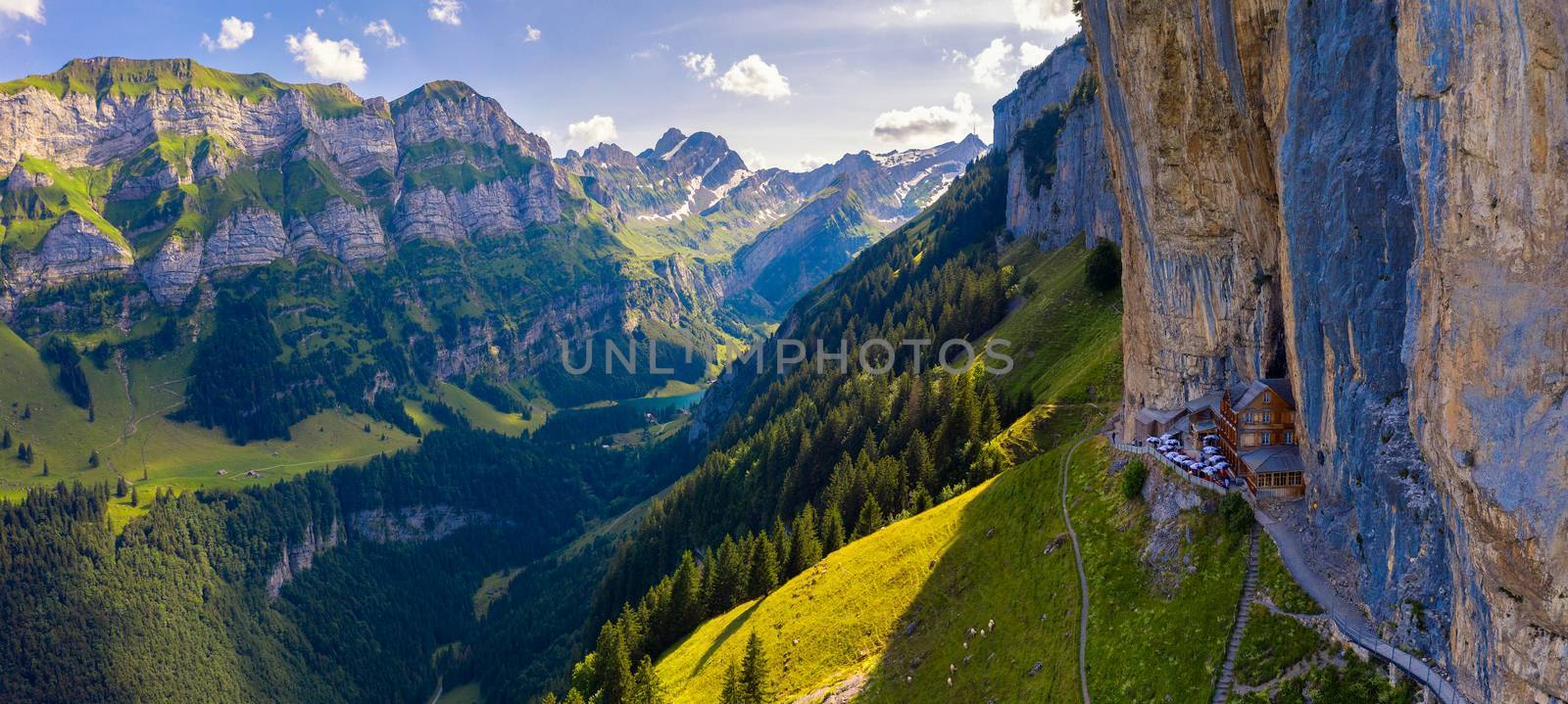 Aerial panorama of the Swiss Alps and a historic mountain restaurant under the Ascher cliff located in the Appenzell region in Switzerland